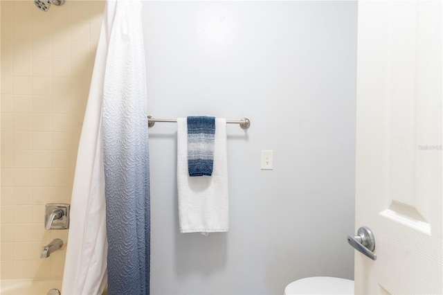 bathroom featuring toilet and shower / bath combo with shower curtain