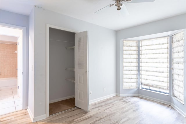 unfurnished bedroom with ceiling fan, light hardwood / wood-style floors, and a closet