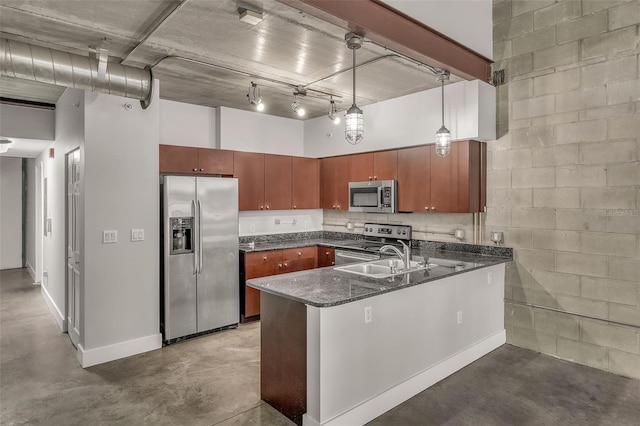 kitchen with sink, stainless steel appliances, kitchen peninsula, concrete flooring, and pendant lighting