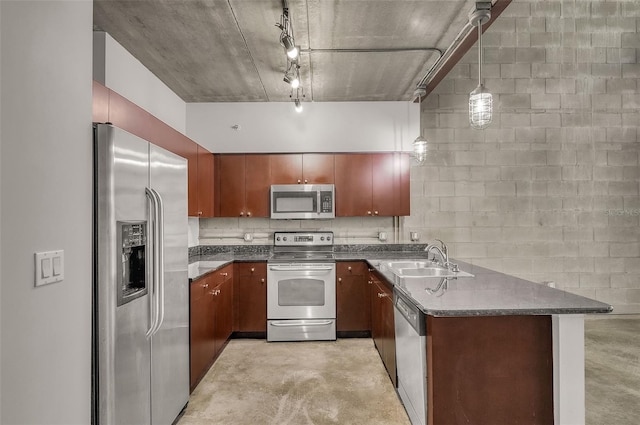 kitchen featuring pendant lighting, sink, rail lighting, kitchen peninsula, and stainless steel appliances