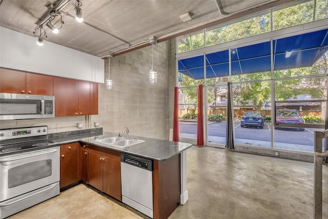 kitchen with sink, a towering ceiling, and stainless steel appliances