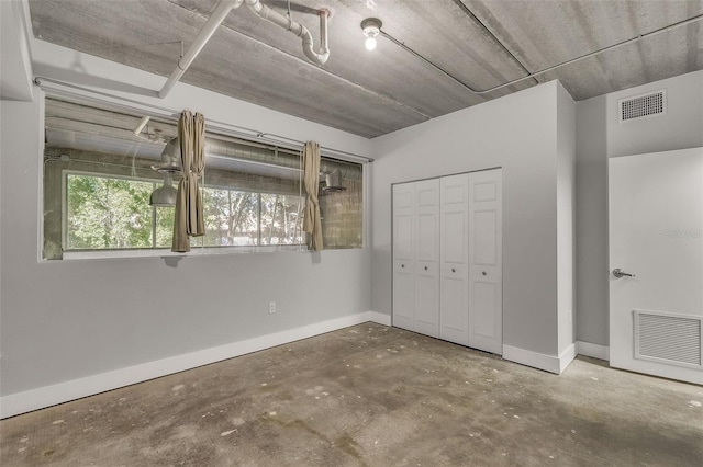 unfurnished bedroom featuring concrete flooring and a closet