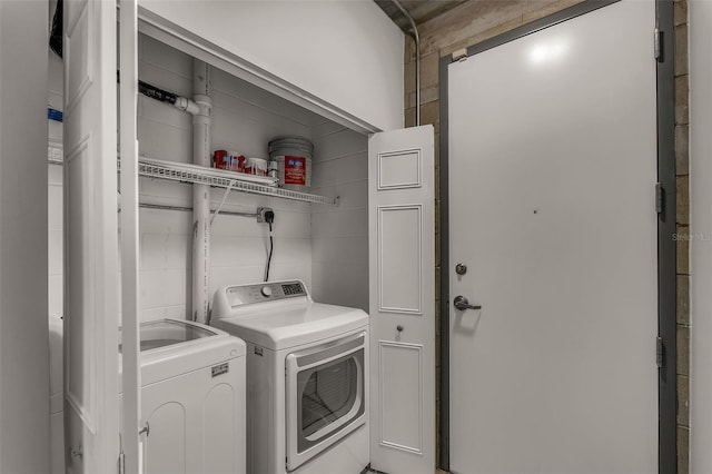 clothes washing area with washer and clothes dryer