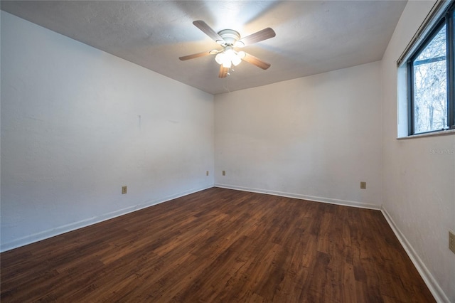 empty room with ceiling fan and dark hardwood / wood-style floors