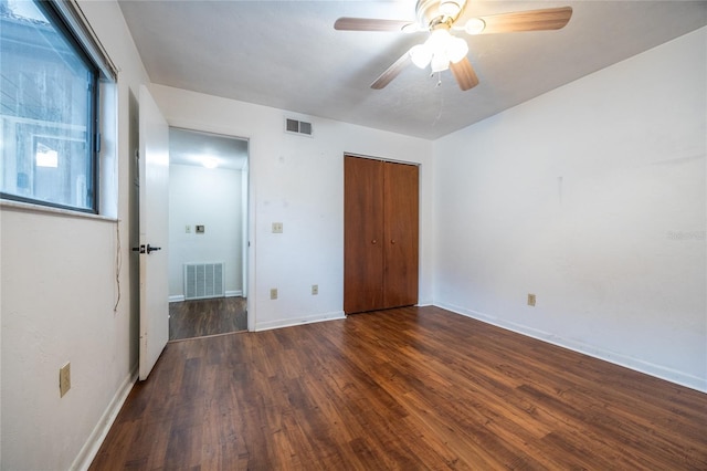 unfurnished bedroom with ceiling fan, a closet, and dark hardwood / wood-style floors