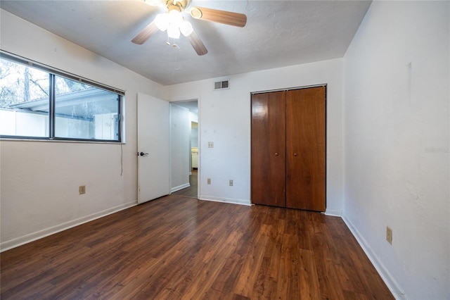 unfurnished bedroom featuring dark hardwood / wood-style flooring, a closet, and ceiling fan