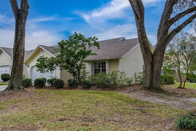 view of front of home with a front lawn and a garage