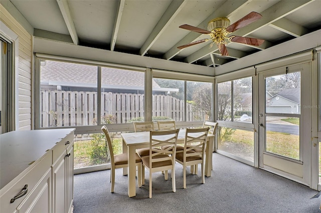 unfurnished sunroom featuring a wealth of natural light, ceiling fan, and lofted ceiling with beams