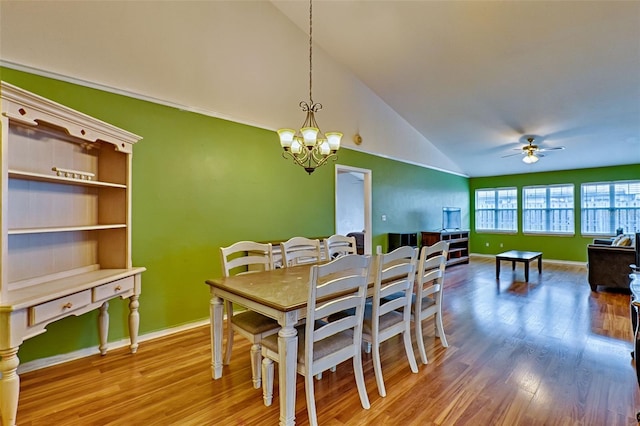 dining room with hardwood / wood-style flooring, ceiling fan with notable chandelier, and lofted ceiling