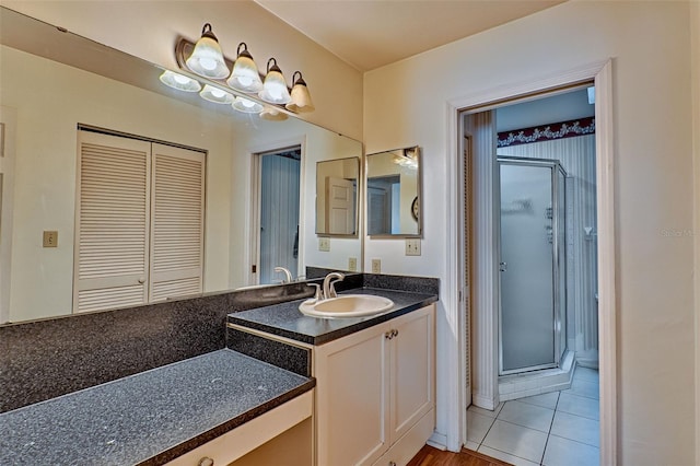 bathroom featuring tile patterned flooring, vanity, and a shower with shower door