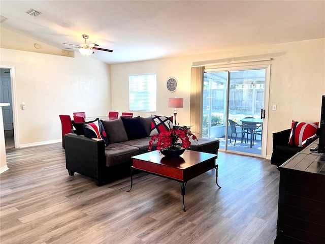 living room with lofted ceiling, ceiling fan, and light hardwood / wood-style floors