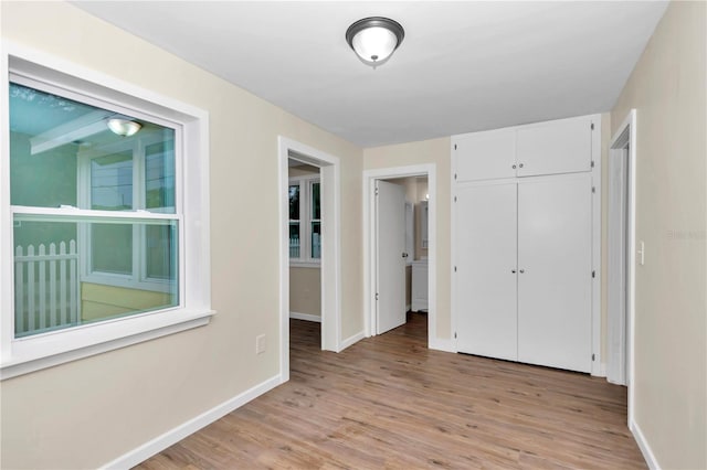 unfurnished bedroom with light wood-type flooring and a closet