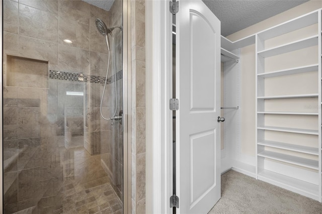 bathroom featuring a shower with shower door and a textured ceiling