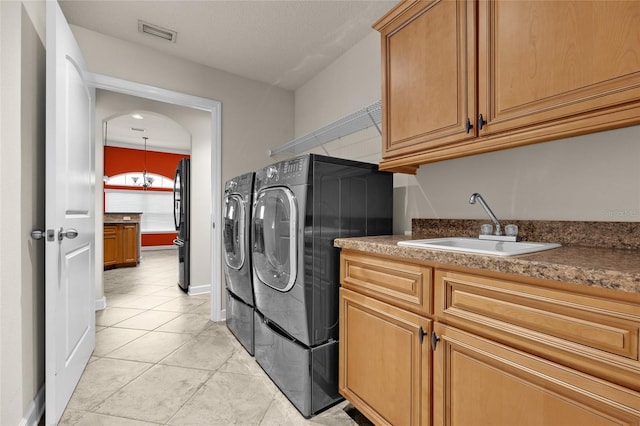 washroom featuring cabinets, separate washer and dryer, light tile patterned floors, and sink