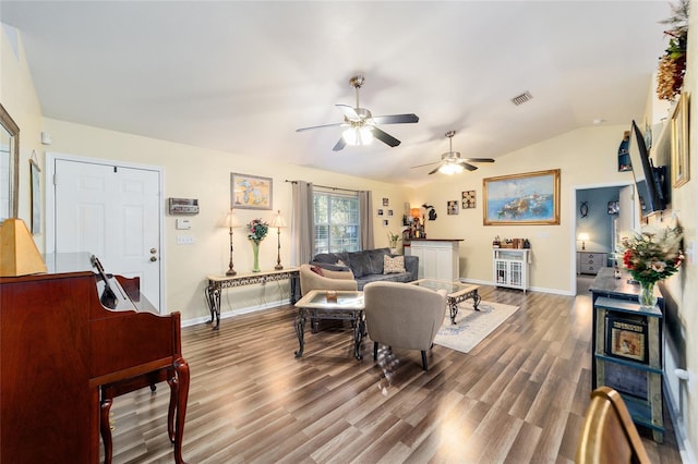 living room featuring ceiling fan, vaulted ceiling, and wood-type flooring