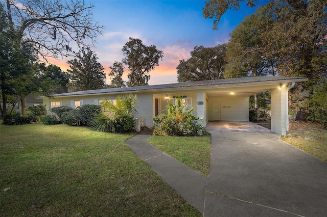 ranch-style home featuring a yard and a carport