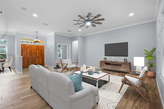 living room with ceiling fan with notable chandelier and ornamental molding