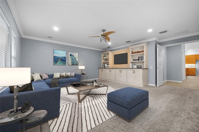 carpeted living room with ornamental molding and ceiling fan