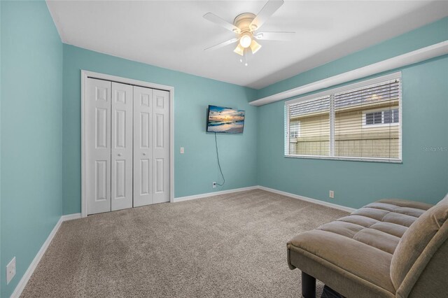 sitting room featuring ceiling fan and carpet