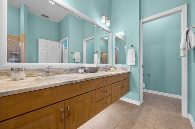 bathroom featuring toilet, a shower with door, vanity, and tile patterned floors