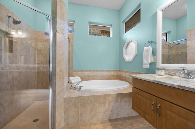 bathroom featuring tile patterned floors, vanity, and shower with separate bathtub