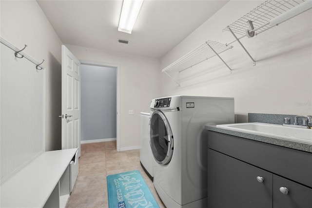 laundry room featuring sink, light tile patterned floors, and separate washer and dryer