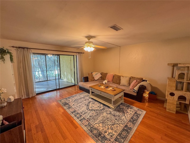 living room featuring ceiling fan and hardwood / wood-style floors