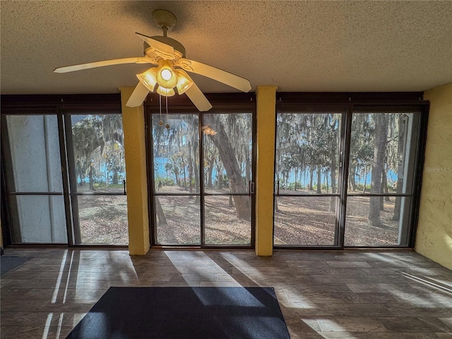 unfurnished sunroom with ceiling fan and plenty of natural light