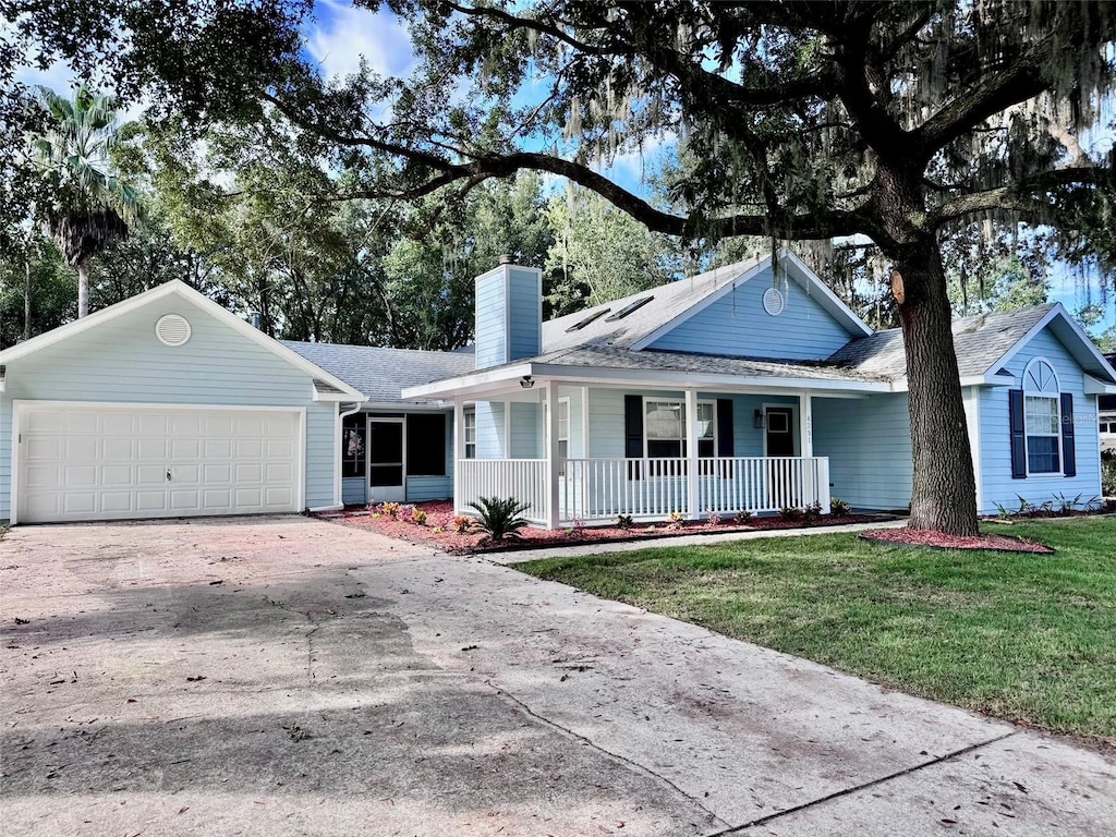 ranch-style house with a porch, a front lawn, and a garage