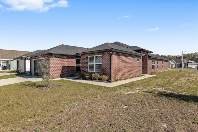 view of side of property featuring a shingled roof, concrete driveway, an attached garage, a yard, and brick siding