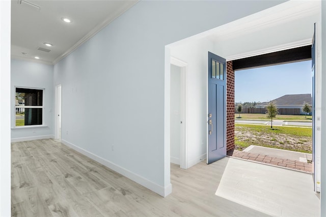 interior space featuring baseboards, crown molding, and wood finished floors