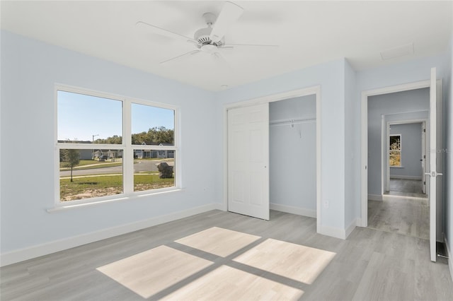 unfurnished bedroom featuring a ceiling fan, light wood-type flooring, a closet, and baseboards