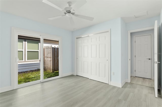 unfurnished bedroom with a closet, multiple windows, light wood-style flooring, and baseboards