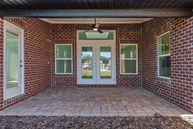 doorway to property featuring ceiling fan, french doors, a patio area, and brick siding