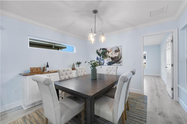 dining room with light wood-type flooring, baseboards, visible vents, and crown molding