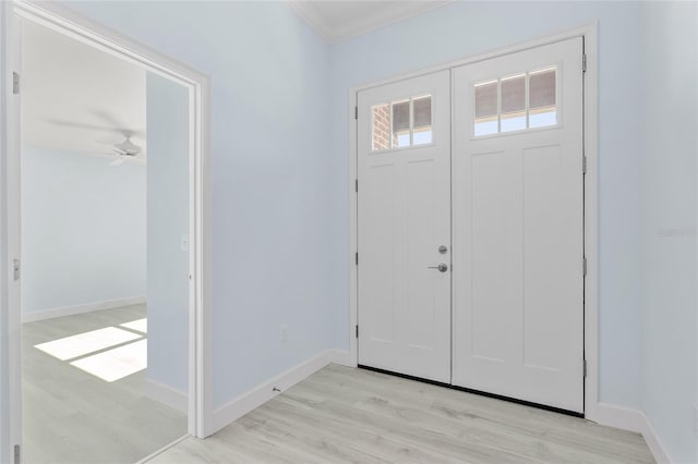 foyer entrance with baseboards, crown molding, and light wood-style floors