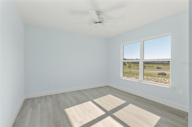 empty room with light wood-style floors, baseboards, and a ceiling fan