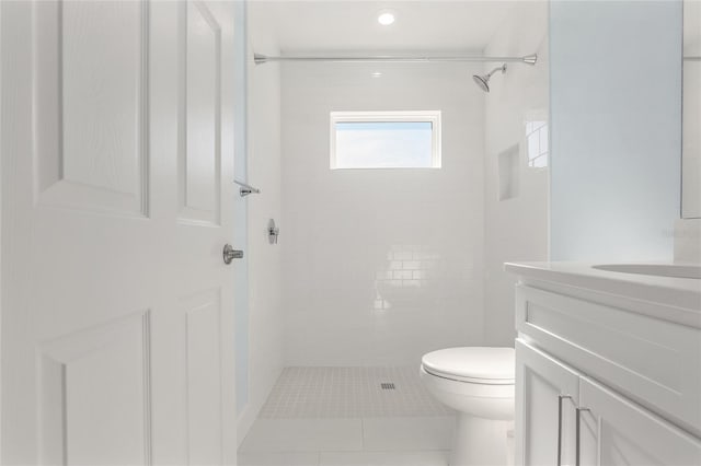 bathroom featuring tiled shower, vanity, and toilet