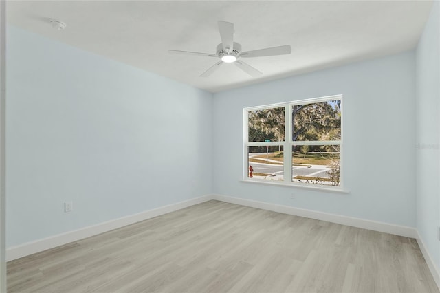 unfurnished room featuring a ceiling fan, light wood-style flooring, and baseboards