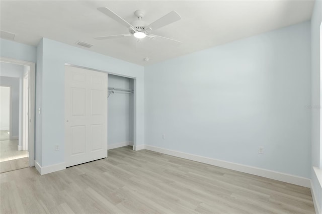 unfurnished bedroom with a closet, visible vents, a ceiling fan, light wood-type flooring, and baseboards