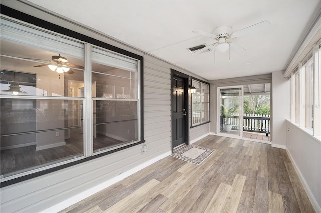 unfurnished sunroom with ceiling fan