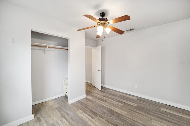 unfurnished bedroom featuring ceiling fan, light wood-type flooring, and a closet