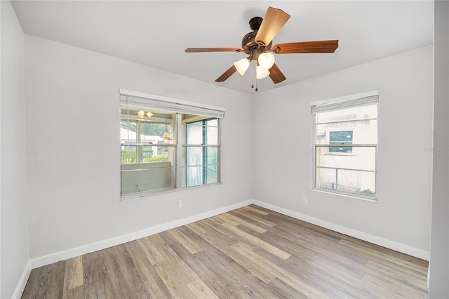 spare room with ceiling fan and light wood-type flooring