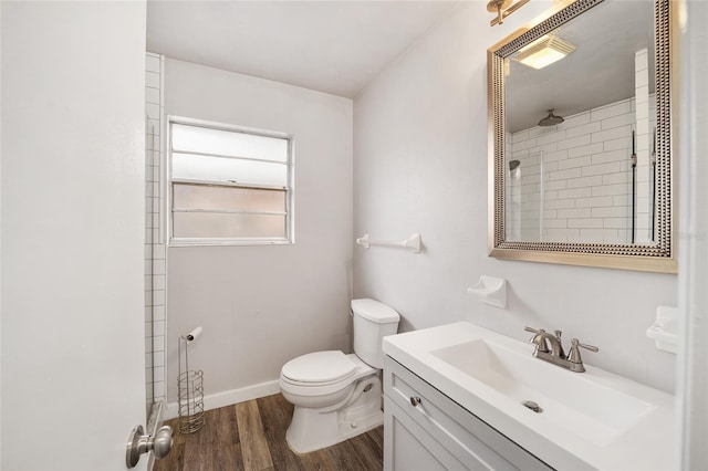 bathroom with toilet, a shower, vanity, and hardwood / wood-style flooring