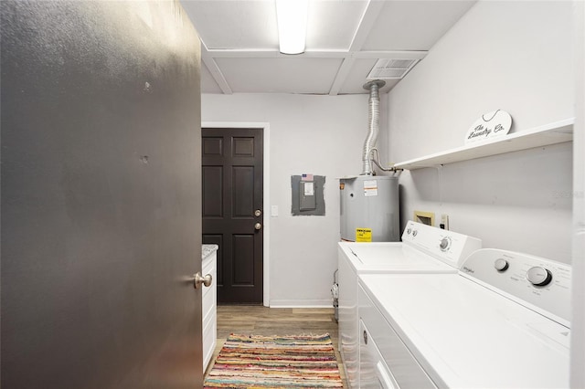 laundry room featuring cabinets, electric panel, dark wood-type flooring, water heater, and washing machine and clothes dryer