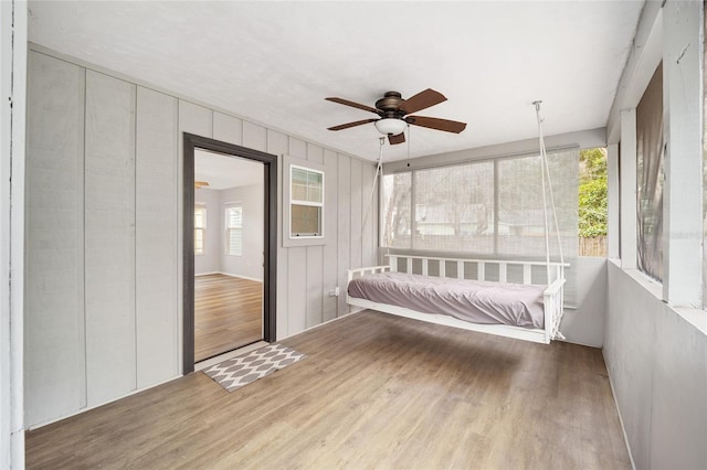 unfurnished sunroom with ceiling fan