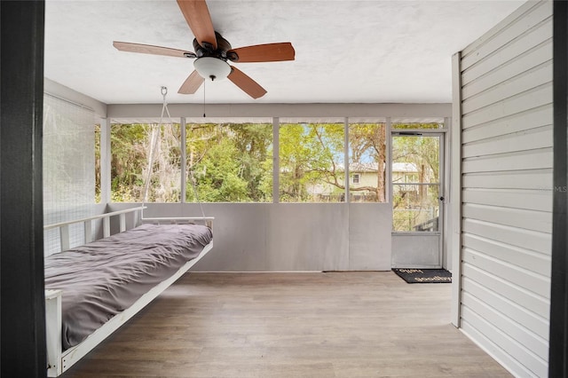 unfurnished sunroom featuring ceiling fan