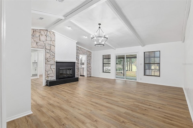 unfurnished living room with a fireplace, a notable chandelier, wood-type flooring, and vaulted ceiling with beams