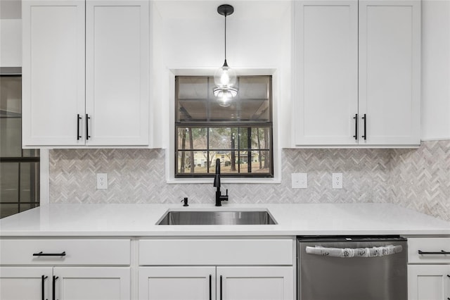 kitchen featuring decorative light fixtures, stainless steel dishwasher, white cabinetry, and sink