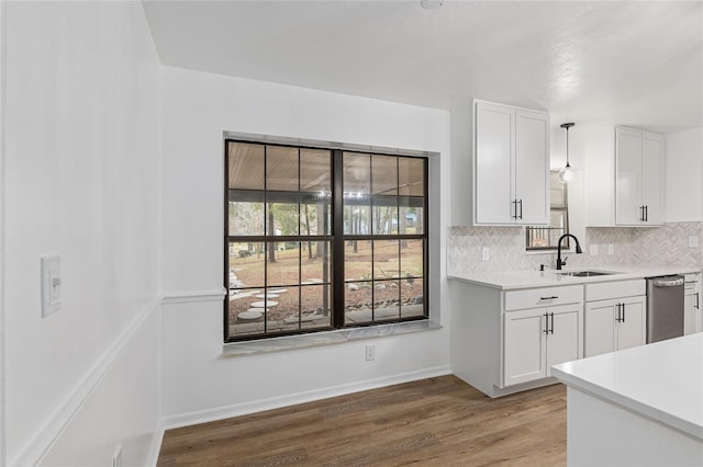 kitchen featuring sink, decorative light fixtures, white cabinets, dishwasher, and tasteful backsplash